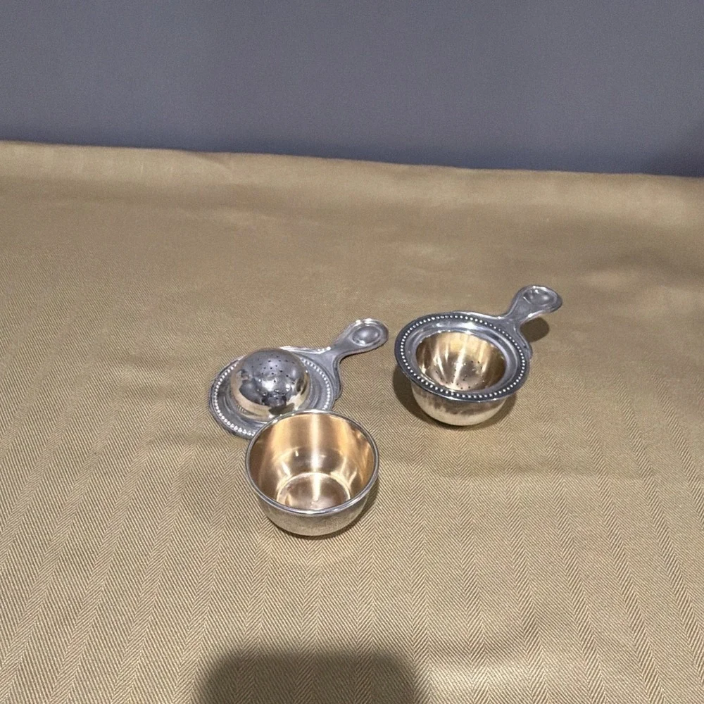 Vintage tea strainers with its matching drip stand.